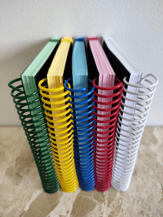 Caderno A5, Espiral da cor do miolo, folhas sem pauta, elástico e ilhós 